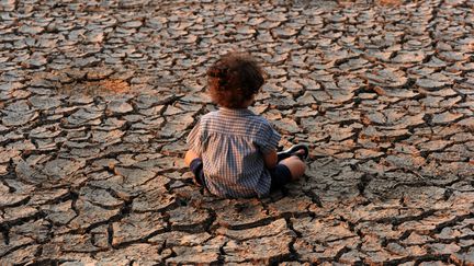 Un enfant sur le sol asséché à&nbsp;Tegucigalpa, au&nbsp;Honduras, le 22 avril 2016. (ORLANDO SIERRA / AFP)