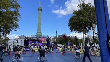 Des spectateurs s'essaient au tennis fauteuil sur la place de la Bastille à Paris, le samedi 8 octobre 2022, lors de la journée paralympique. (Clément Pons / franceinfo: sport)