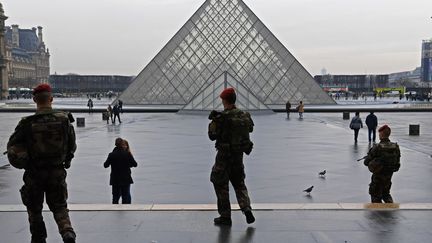 Des militaires de l'opération Sentinelle, le 16 févier 2017, devant la pyramide du Louvre.&nbsp; (CHRISTOPHE ARCHAMBAULT / AFP)