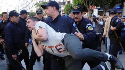 Un manifestant du mouvement Barakat est &eacute;vacu&eacute; par un policier, mercredi 16 avril &agrave; Alger (Alg&eacute;rie).&nbsp; (FAROUK BATICHE / AFP)