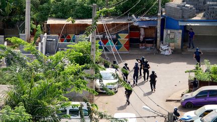 Policiers et policiers du Raid, lors d'une opération contre l'immigration clandestine dans le village de Vahibe, à Mayotte, le 28 novembre 2022 (GREGOIRE MEROT / AFP)