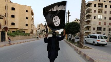 Militant de Daech brandissant un drapeau de l'organisation djihadiste à Racca (centre de la Syrie), le 29 juin 2014. (Reuters)