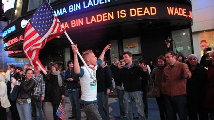 Des passants r&eacute;agissent &agrave; l'annonce de la mort d'Oussama Ben Laden &agrave; Times Square, New York, le 2 mai 2011. (ERIC THAYER / REUTERS)