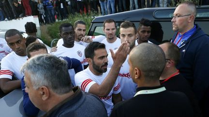 Le capitaine de l'équipe de l'AC Ajaccio essaie de parler avec les joueurs du Havre alors le bus de ces derniers était endommagé par des supporters corses. (PASCAL POCHARD-CASABIANCA / AFP)