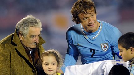 Le pr&eacute;sident uruguayen Jos&eacute; Mujica, dit "Pepe", avec le d&eacute;fenseur Diego Lugano, au Centenario Stadium, &agrave; Montevideo (Uruguay), le 4 juin 2014. (MIGUEL ROJO / AFP)