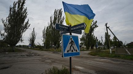 Un drapeau ukrainien flotte dans la rue du village de Vysokopillya, dans la région de Kherson (Ukraine), le 27 septembre 2022.&nbsp; (GENYA SAVILOV / AFP)