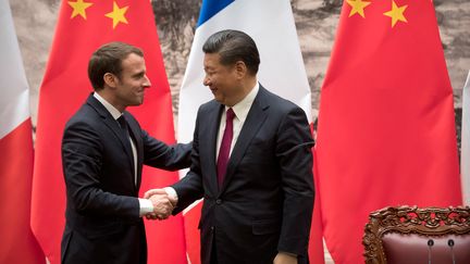 Le président de la République Emmanuel Macron serre la main de son homologue chinois Xi Jinping après une conférence de presse commune à Pékin, le 9 janvier 2018. (MARK SCHIEFELBEIN / AFP)