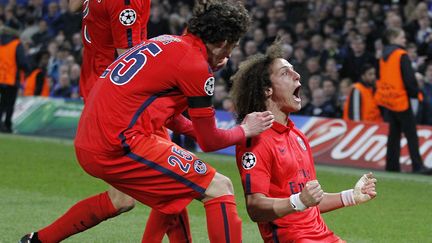 Le d&eacute;fenseur du PSG David Luiz (&agrave; droite) f&eacute;licit&eacute; par ses &eacute;quipiers lors du match Chelsea-PSG, le 11 mars 2015. (IAN KINGTON / AFP)