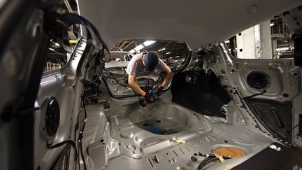 Un ouvrier travaille sur un mod&egrave;le de Peugeot 208 &agrave; l'usine PSA de Poissy (Yvelines), le 29 avril 2015. (BENOIT TESSIER / REUTERS)