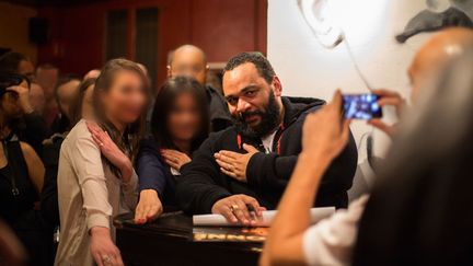 Dieudonn&eacute;&nbsp;(C) et deux admiratrices font une quenelle &agrave; l'issue du spectacle de l'humoriste au th&eacute;&acirc;tre de la Main d'Or &agrave; Paris, le 4 janvier 2014. (CITIZENSIDE / AFP)