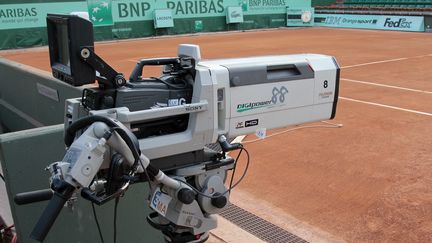 Une camera de télévision installée sur un court du tournoi de Roland Garros, à Paris. (JACQUES DEMARTHON / AFP)