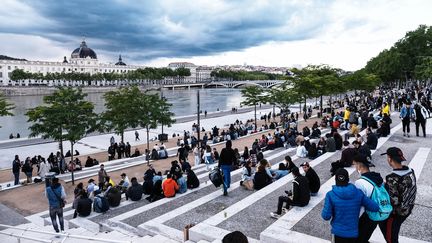 Des promeneurs s'installent sur les bords du Rhône lors du déconfinement à Lyon, le 19 mai 2021. (ANTOINE MERLET / HANS LUCAS)