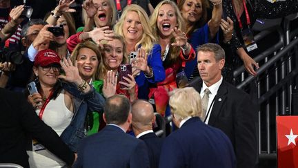 Des fans acclament Donald Trump devant le lieu de la convention du parti républicain, le 16 juillet 2024. (LEON NEAL / GETTY IMAGES NORTH AMERICA / AFP)