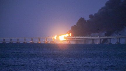 L'incendie sur le pont automobile et ferroviaire reliant la péninsule ukrainienne de Crimée, annexée par la Russie, et le territoire russe, le&nbsp;8 octobre 2022. (VERA KATKOVA / ANADOLU AGENCY / AFP)