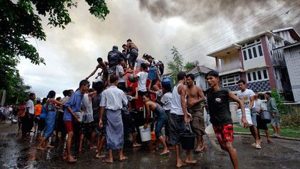 aident les pompiers à éteindre le feu mis à leurs maisons.

En 1982, une loi promue par le dictateur Ne Win leur impose de prouver leur présence sur le territoire avant 1823 pour leur permettre d’obtenir la nationalité birmane, une démarche quasi impossible à accomplir.

Sans carte d’identité et, donc, sans nationalité, ils deviennent des non-citoyens, un peuple apatride. (REUTERS/Reuters Staff)