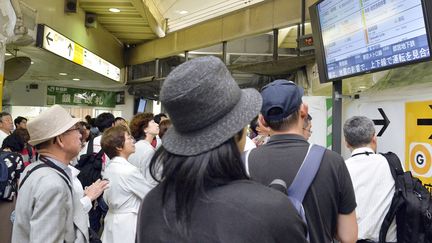 Des passagers consultent des horaires de train, le 30 mai 2015, &agrave; Tokyo (Japon). (KYODO KYODO / REUTERS)