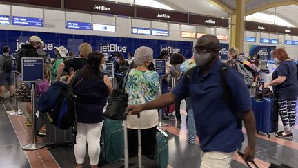 Des passagers à l'aéroport de Washington (Etats-Unis), le 1er août 2021. (DANIEL SLIM / AFP)