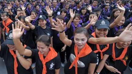 Le chef de la police de Bangkok, le général Kamronwit Thoopkrajang, a permis fin 2013 à des milliers de manifestants d’investir son QG qui «appartient au peuple». Après plusieurs jours d'affrontements (5 morts), le gouvernement a demandé aux policiers de ne pas s'interposer. 

Le 4 décembre 2013, des femmes officiers de police saluent les opposants au régime lors de leur départ du siège de la police à Bangkok. Une trêve temporaire a été décrétée pour préparer l'anniversaire du roi. (PORNCHAI KITTIWONGSAKUL / AFP)