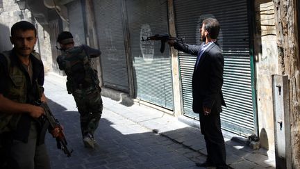 Des rebelles syriens tirent sur des soldats de l'arm&eacute;e gouvernementale &agrave; Alep (Syrie), le 21 ao&ucirc;t 2012. (PHIL MOORE / AFP)