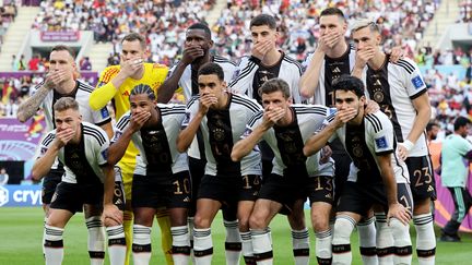 Privée de porter un brassard "One Love" pour dénoncer des discriminations, la sélection allemande répond à la Fifa en se bâillonnant, avant sa défaite contre le Japon (1-2), le 23 novembre 2022. (CHRISTIAN CHARISIUS / AFP)