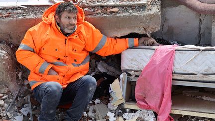 Un père tient la main de sa fille morte sous les décombres à Kahramanmaras (Turquie), après le violent séisme, le 7 février 2023. (ADEM ALTAN / AFP)