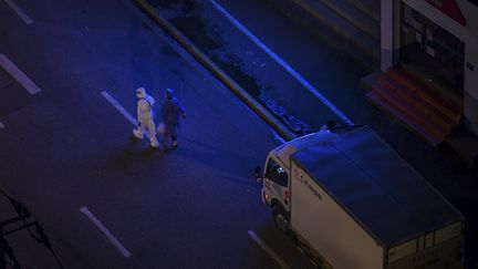 Des fonctionnaires des autorités sanitaires dans une rue confinée. Image d'illustration. (HECTOR RETAMAL / AFP)