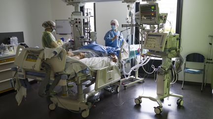 Des soignants sont au chevet d'un patient en réanimation à l'hôpital Louis-Pasteur de Colmar (Haut-Rhin), le 26 mars 2020.&nbsp; (SEBASTIEN BOZON / AFP)