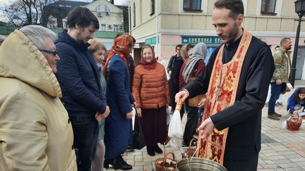 Devant l'église Saint-Michel de Kiev, de nombreux paroissiens attendent la bénédiction du prêtre, le 24 avril 2022. (FARIDA NOUAR / FRANCEINFO)