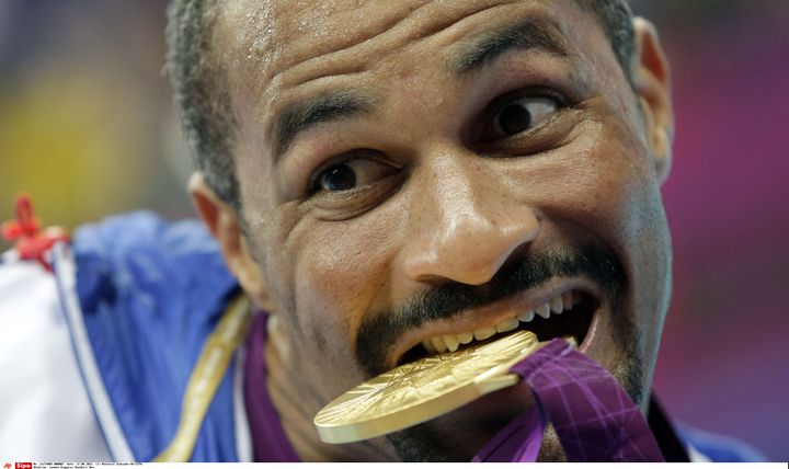 Le handballeur Didier Dinart, médaille d'or dans la bouche, lors des Jeux de Londres le 12 août 2012. (MATTHIAS SCHRADER/AP/SIPA / AP)