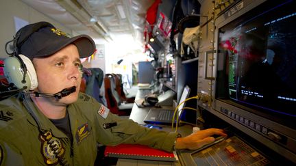 Un analyste de l'arm&eacute;e de l'air australienne surveillant un radar &agrave; bord d'un avion Orion, &agrave; la recherche des d&eacute;bris du vol MH370, le 19 mars 2014 dans l'oc&eacute;an Indien. (HAMISH PATERSON / AUSTRALIAN DEFENCE)