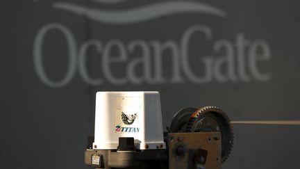 Une pièce d'équipement avec le logo "Titan", devant le logo OceanGate sur un bâtiment, le 22 juin 2023 à Washington (Etats-Unis). (JASON REDMOND / AFP)