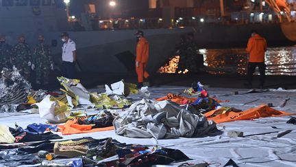 Des enquêteurs indonésiens étudient, le 11 janvier 2021 à Jakarta, les débris retrouvés après le crash en mer d'un Boeing de Sriwijaya Air deux jours plus tôt. (ADEK BERRY / AFP)