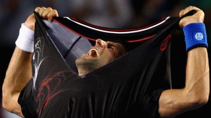 Le Serbe Novak Djokovic c&eacute;l&egrave;bre sa victoire &agrave; l'open de tennis d'Australie &agrave; Melbourne, le 30 janvier 2012. (RYAN PIERSE / AFP)