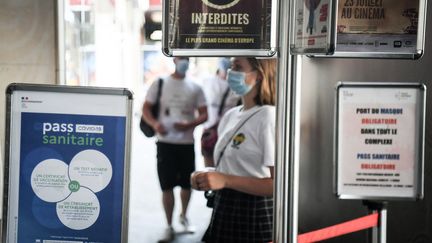 Des spectateurs font la queue avant de faire contrôler leur pass sanitaire à l'entrée du cinéma Grand Rex à Paris, le 21 juillet 2021. (ALAIN JOCARD / AFP)