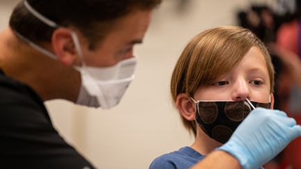 Un élève&nbsp;subit un test PCR dans son établissement à Louisville (Etats-Unis), le 29 octobre 2021. (JON CHERRY / GETTY IMAGES NORTH AMERICA / AFP)