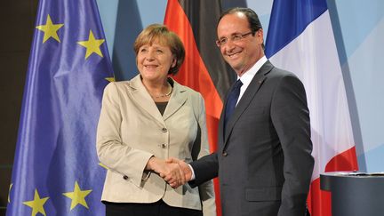 Poign&eacute;e de main entre Angela Merkel et Fran&ccedil;ois Hollande &agrave; l'issue de leur premi&egrave;re conf&eacute;rence de presse commune, &agrave; Berlin (Allemagne), le 15 mai 2012. (BERTRAND LANGLOIS / AFP)