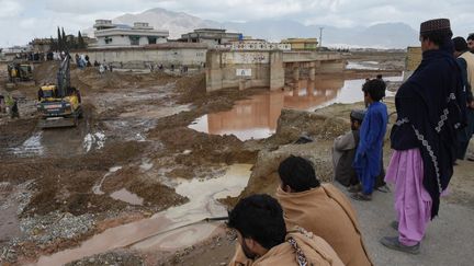 Des personnes devant les dégâts causés par les fortes pluies à Quetta, capitale de la province du Balouchistan (Pakistan), le 15 avril 2024. (BANARAS KHAN / AFP)