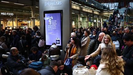 Des passagers attendent à la gare de Saint-Pancras, à Londres, le 30 décembre 2023, alors que le service Eurostar est perturbé en raison d'inondations. (HENRY NICHOLLS / AFP)