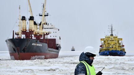 Un navire brise-glace devant un porte-conteneurs dans le cercle arctique, en mai 2016.&nbsp; (KIRILL KUDRYAVTSEV / AFP)