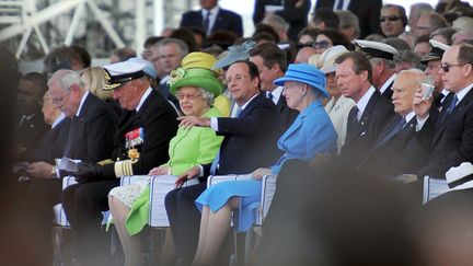 Loin de passer inaper&ccedil;ue avec sa tenue vert pomme, Elizabeth II assiste, aux c&ocirc;t&eacute;s de Fran&ccedil;ois Hollande &agrave; une c&eacute;r&eacute;monie internationale &agrave; l'occasion des 70 ans du D&eacute;barquement &agrave; Ouistreham (Calvados). (GUILLAUME SOUVANT / AFP)