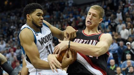 Le joueur de Minnesota Karl-Anthony Towns (en blanc) face à Mason Plumlee de Portland (en noir et rouge) (HANNAH FOSLIEN / GETTY IMAGES NORTH AMERICA)