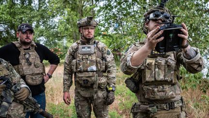 Des soldats ukrainiens testent un drone armé d'une bombe pour cibler les positions russes sur la rive gauche du fleuve Dnipro, le 26 mai 2023. (VIRGINIE NGUYEN HOANG / HANS LUCAS / AFP)