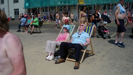 Un couple prend un bain de soleil &agrave;&nbsp;Bournemouth (Royaume-Uni), le 14 juillet 2013. (KIERAN DOHERTY / REUTERS)