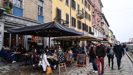 Des clients sont assis à la terrasse de bars et de restaurants, le 6 février 2021, à Milan (Italie). (MIGUEL MEDINA / AFP)