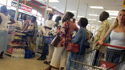 File à la caisse d'un supermarché en Cote d'Ivoire, au lendemain des violences du 11 novembre 2004. (ISSOUF SANOGO / AFP)