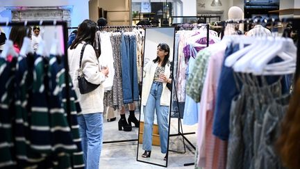 Une cliente essaie des vêtements de la marque Shein, à Paris, le 4 mai 2023. (CHRISTOPHE ARCHAMBAULT / AFP)