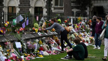 Des passants déposent des fleurs sur les lieux de l'attaque d'une mosquée à&nbsp;Christchurch (Nouvelle-Zélande), le 16 mars 2019. (ANTHONY WALLACE / AFP)