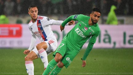 Ryad Boudebouz (à droite) et&nbsp;Maxence Caqueret lors du match entre Saint-Etienne et Lyon, le 3 octobre 2021 à Saint-Etienne. (PHILIPPE DESMAZES / AFP)