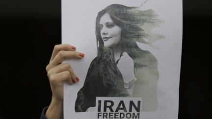 Un portait de Masha Amini brandi lors d'une manifestation à Mexico (Mexique) devant l'ambassade de la République islamique d'Iran, le 27 septembre 2022. (GERARDO VIEYRA / NURPHOTO / AFP)