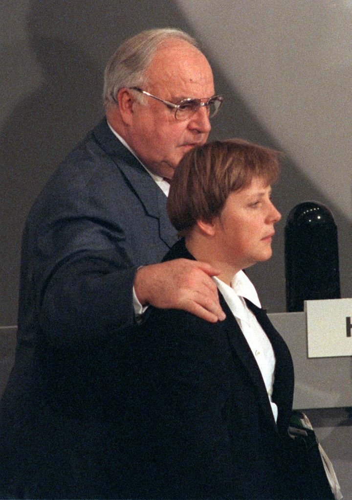 Helmut Kohl pose sa main sur l'épaule d'Angela Merkel, pendant une conférence de son parti, la CDU, à Bonn le 28 novembre 1994. (TIM BRAKEMEIER / DPA)